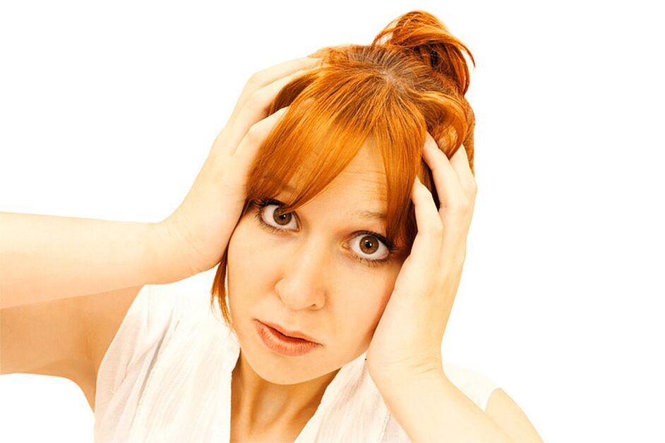 Una mujer sostiene la cabeza